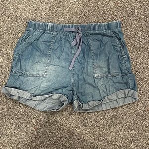 Dark blue cargo shorts in dark blue with an ig also me strap on the waste.